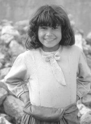 Girl standing in front of her family’s mud-brick home near Aleppo.