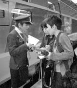 A French conductor assists visitors boarding the new TGV Est train. 