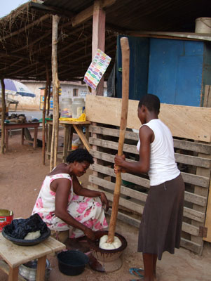 Making fufu requires coordination and confidence in your partner. While one person lifts the stick, the other turns the dough.