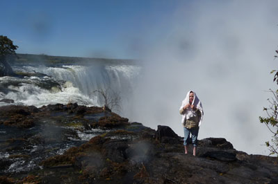 Regine standing on a tiny island on the edge of Victoria Falls. 