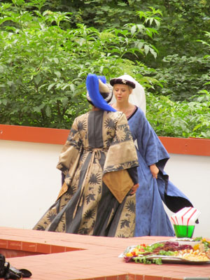 Women in 16th-century dress dancing on the grounds of Raudonvaris Castle.