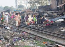 Trains run all day through the Dhaka slums.