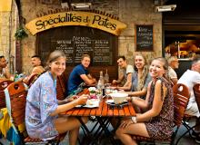 Locals are eager to share their culture with an approachable traveler, such as at this “meet-up” dinner in Nice, France. Photo by Dominic Arizona Bonuccelli