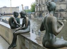 Bronze statues lining the Spree River.