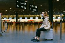 Woman sitting on luggage. 