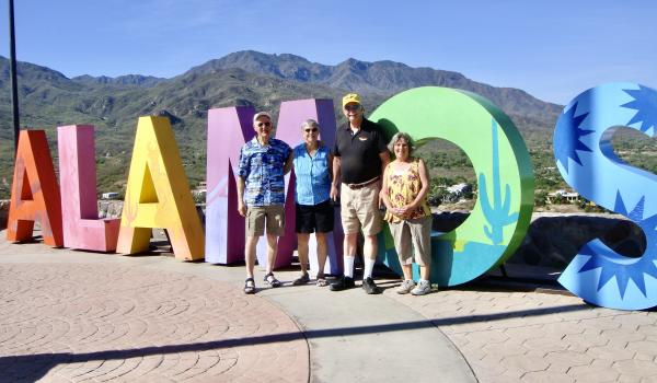 This sign sits atop Mount Alamos. Left to right: Tom and Lynn Meadows and friends Vince and Susan.