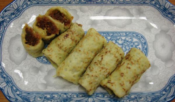 Kueh Dadar on a plate decorated with a typical Peranakan design.