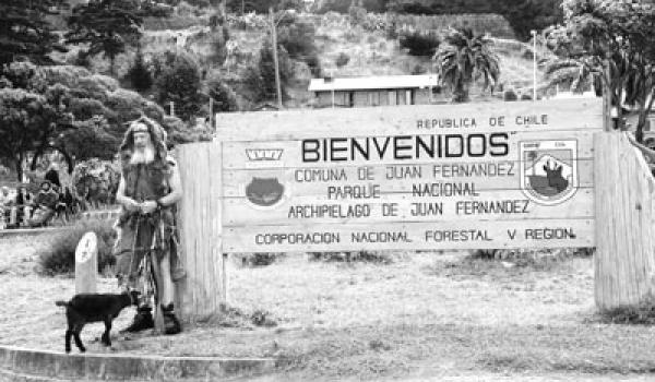 “Robinson Crusoe” beside the island’s welcome sign.