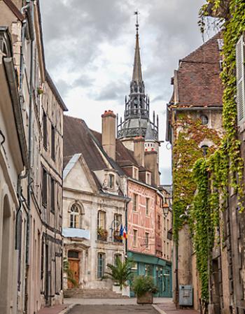 The 15th-century Tour de l’Horloge (Clock Tower) peeks above medieval buildings in the Old Town of Auxerre, France.