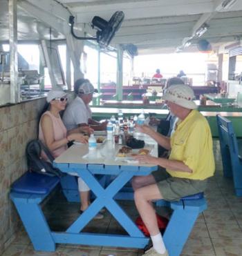 Left: Dining at the lolo Sky’s the Limit in Grand Case, Saint-Martin. Right: A smoking oven in use at Sky’s the Limit. Photos by Randy Keck