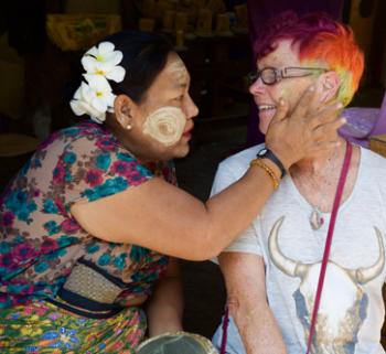 A vendor in a market in Yangon applied thanaka to Kristan Otto, a passenger on the AmaPura. 